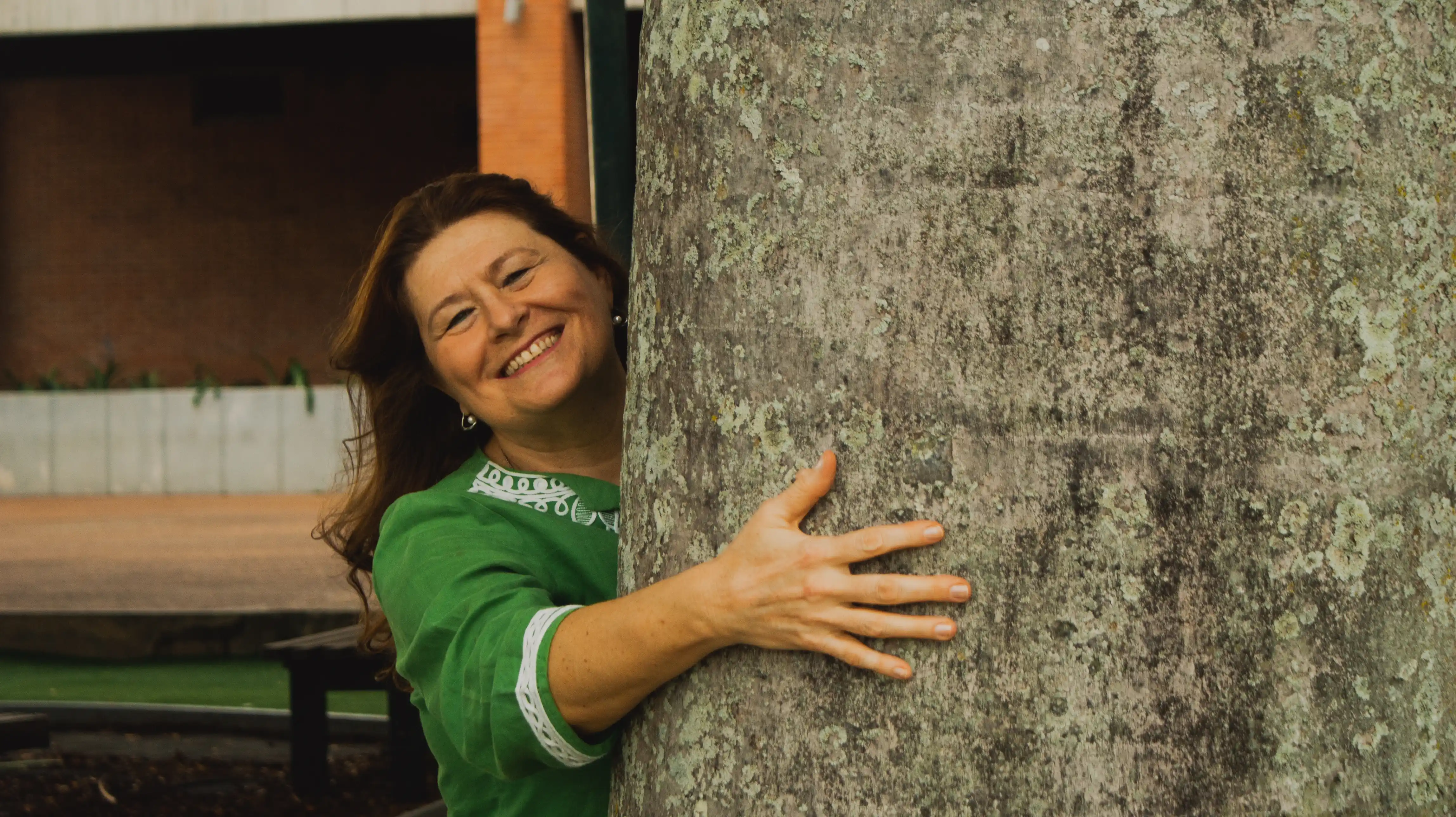 foto de mujer sonrriendo abrazando un arbol